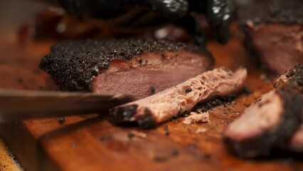 Pitmaster carves juicy lean Texas barbecue smoked brisket, carefeully slicing tender beef brisket for bbq plates, slow motion close up 4K
