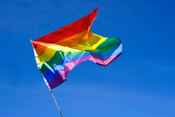 gay pride flag fluttering in the wind on a sunny day.