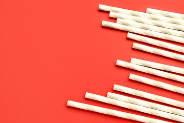 Stylish straws for drinks on red background