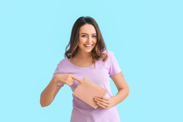 Young woman with envelope on color background