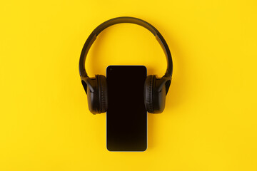 blank smartphone with headphone over yellow background