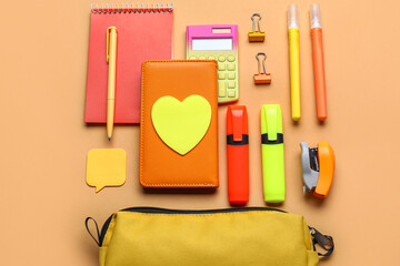 Yellow pencil case with stationery supplies on beige background