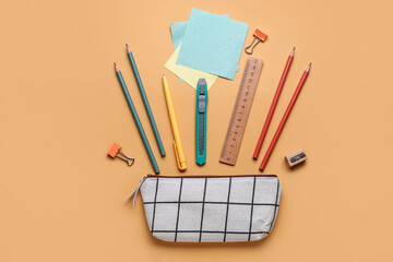 Checkered pencil case with stationery supplies on beige background