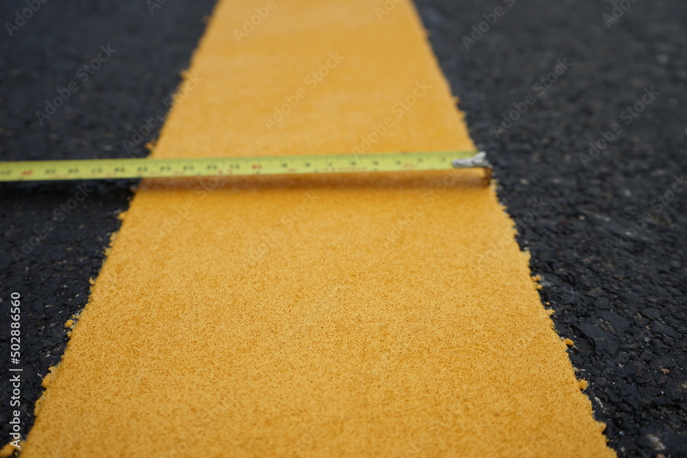 Sticker Blurred image of yellow traffic marking work on paved road