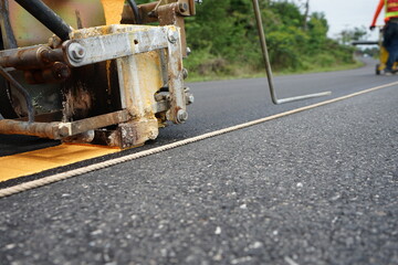 Blurred image of yellow traffic marking work on paved road