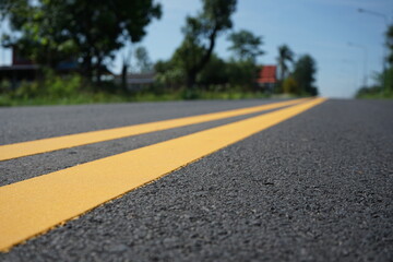 Blurred image, paved road and yellow traffic markings