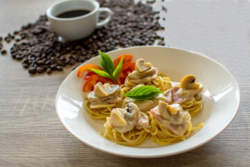 Plate of delicious pasta with mushrooms on table