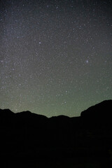 Vertical shot of starry night sky with silhouette of mountains in Chile