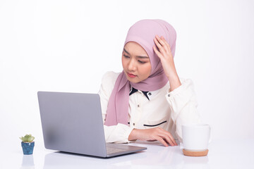 Female muslim business working on laptop and stressed in the office. Copy space.