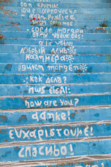 Steps of the stairs to a restaurant with a welcome greeting in different languages on each step