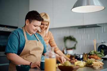 Happy gay woman preparing food with her girlfriend in kitchen.