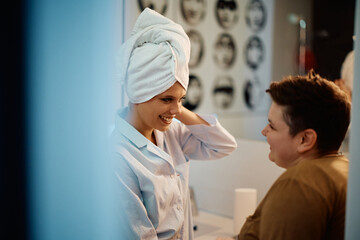 Fototapeta premium Young happy woman talks to her girlfriend in bathroom.