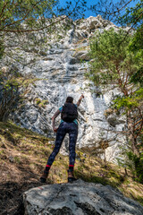 Hiker girl showing on large rock formation called Cerenova skala in Slovakia