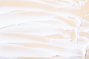 White cream brush strokes top view on beige background