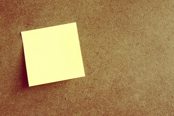 yellow post it paste on brown wood background have copy space for put text to do list