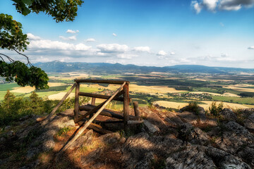 Fototapeta na wymiar Lonely empty bench with beautiful view on summer countryside on hill called Ondrasovska skala, Slovakia