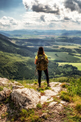Hiking girl with backpack looking on beautiful summer mountain landscape from hill Cipcie in Slovakia