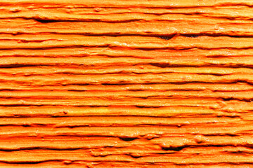 Lot of parallel thick strokes of orange paint on canvas. Abstract texture with line structure