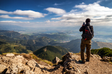 Hiker on top of the hill Velky Choc making photo of beautiful mountain landscape in Slovakia