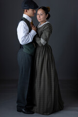 A working class Victorian couple standing together against a studio backdrop