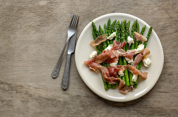 Green asparagus with mozzarella cheese and prosciutto ham. Seasonal delicious food. keto dietary lunch or dinner.