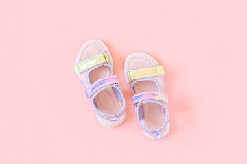 Stylish holographic sandals for kids on pink background. Shiny fashion summer shoes. Flat lay, Top view