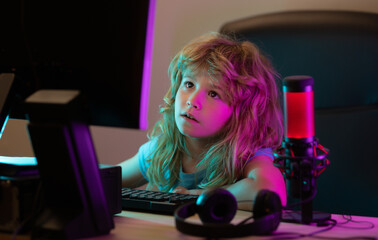 Kid using pc at night. Child with computer in a dark room. School, study, online learning concept.