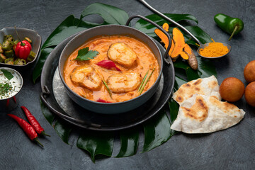 Kerala fish curry on dark background.