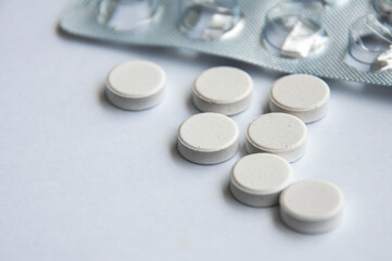 Pharmaceutical tablets and capsules with blurred background over white background. Concept of healthcare and medicine.