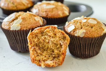 Homemade muffins. Muffins in a baking dish. Muffins garnished with almonds. Muffins on a white background.