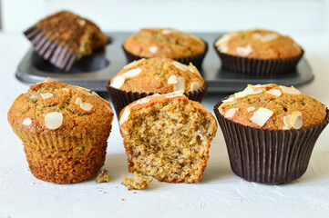 Homemade muffins. Muffins in a baking dish. Muffins garnished with almonds. Muffins on a white background.