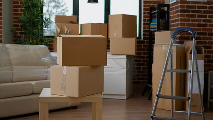 Empty new apartment space with furniture packages in boxes, moving in household property. No people in real estate house to move with things in storage cardboard cargo containers.