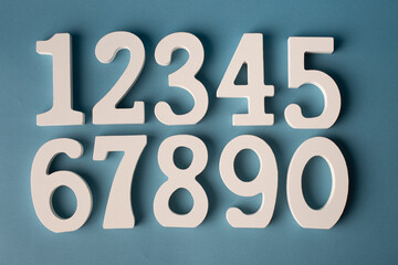 Set of white wooden numbers on blue background.