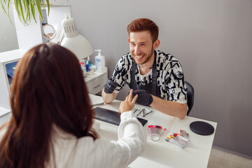Manicure specialist providing nail service for client in salon
