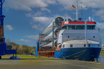 Moored  ship in port loaded with wind turbine blades. Transportation of blades for wind turbines on...