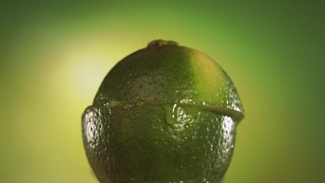 Half Lime falling and splashing on green background. Food levitation concept. Slow Motion