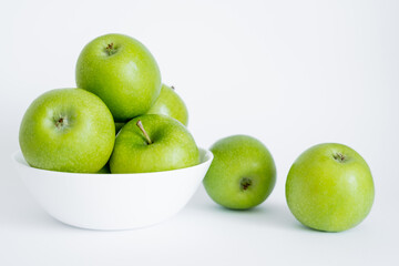 bowl with green and healthy apples on white.