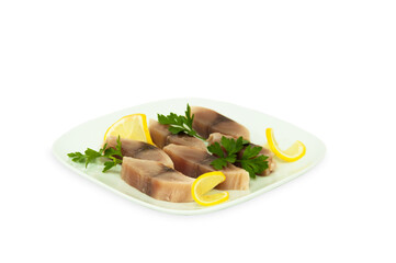 herring pieces with lemon and greenery parsley and on white plate isolated
