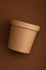 Brown crafted paper cup for soup on dark brown background. Eco package. Zero Waste. Mock up for branding.