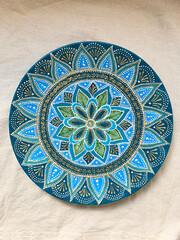 Decorative ceramic plate with  different colors. painted plate on white background, closeup, top view. Decorative porcelain plate painted with acrylic paints, dot painting