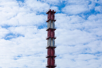 Beautiful bright, vivid and colorful view, scene or scenery of tall pipe or tube tower on the background of blue sky with white clouds in daylight