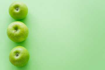 top view of row with fresh apples on green.