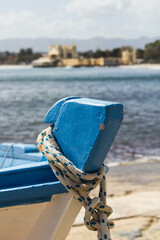 evocative close-up image of the bow of a boat
boats moored in the harbor in a small
fishing village in Sicily, Italy