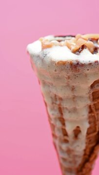 side pan melting ice cream cone of vanilla flavor close up on a pink background