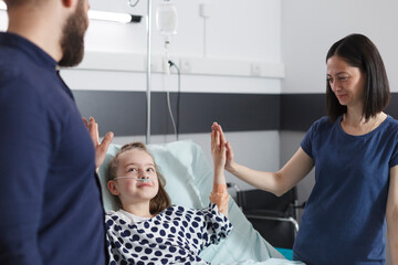 Obraz premium Happymother and father congratulating ill little daughter for successful treatment and recovery results. Peaceful relaxed parents congratulating sick child for amazing health results