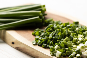 ​​Green onions cut on a wooden board.