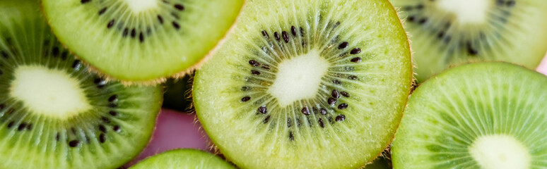 top view of sliced green kiwi on pink, banner.