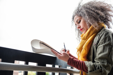 Attractive mature woman artist making a drawing on a sketchbook.