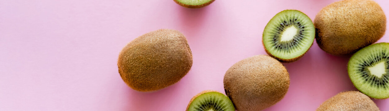 top view of cut green kiwi on pink, banner.