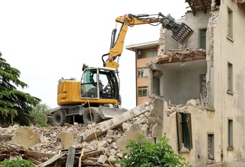 Wheeled excavator demolishing an old building for an urban redevelopment.